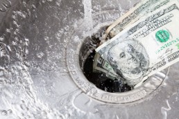 money pouring down a drain