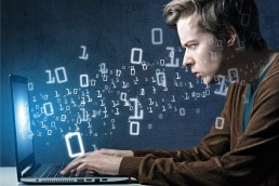 Man at laptop with binary codes
